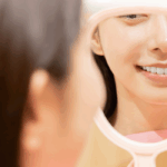 鏡で歯を確認する女性